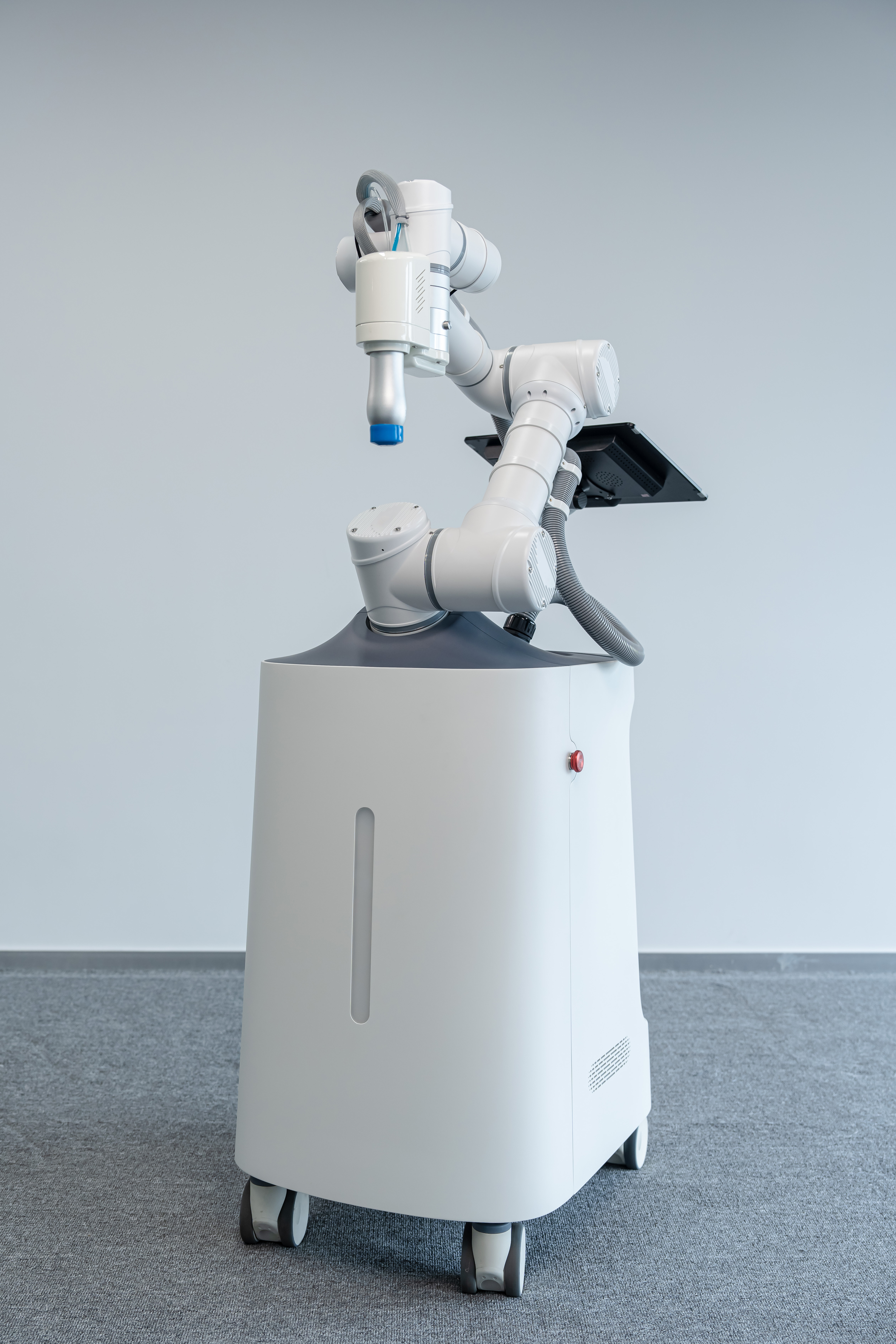 White robotic arm massage device with mobile base, touchscreen, emergency stop and status light