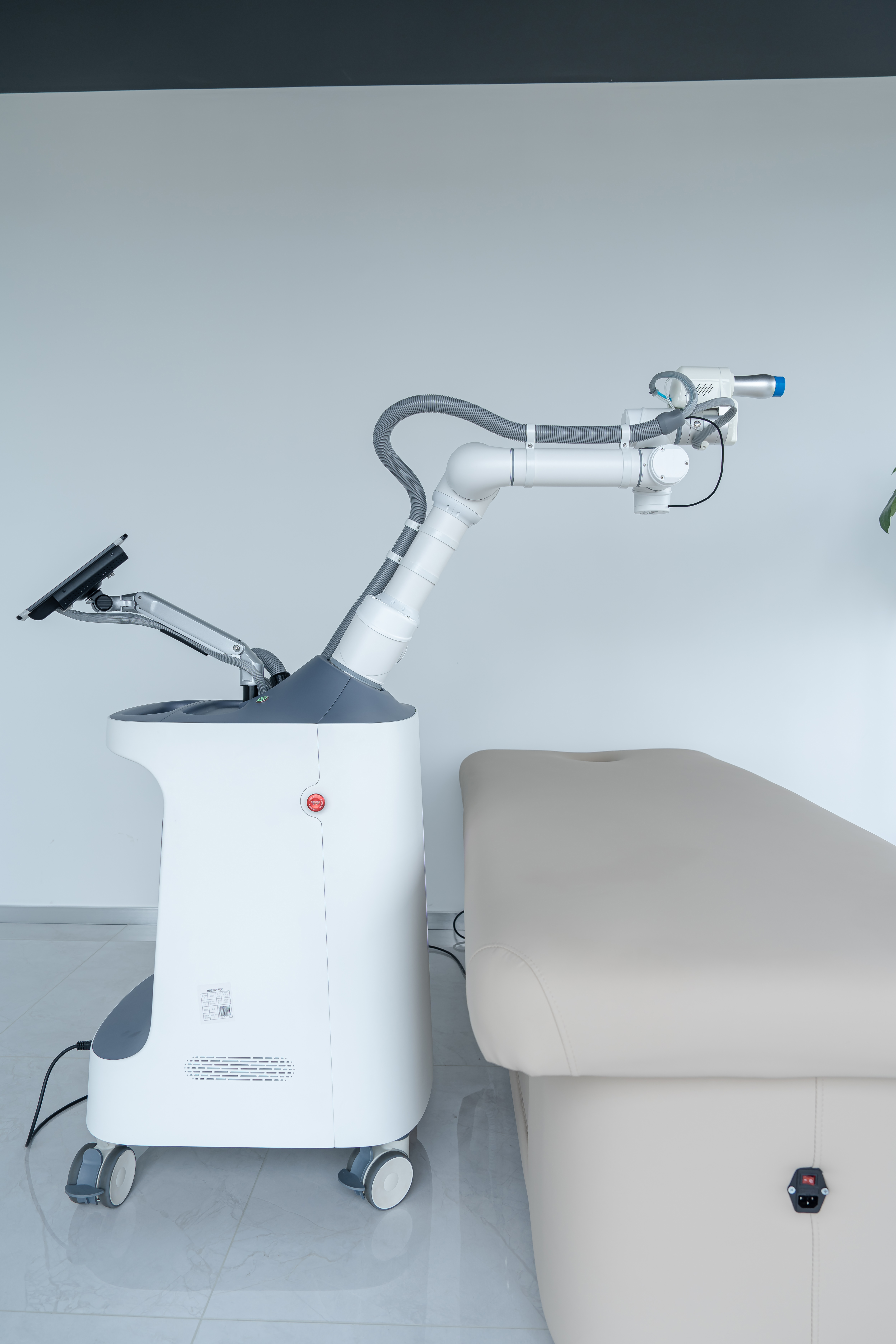 myosbot robotic massage device positioned beside a treatment bed